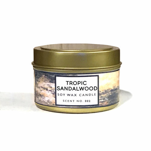 Smaller candle, this time in gold tin with gold, black, and brown marbled label with title "Tropic Sandalwood"